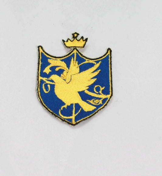 Shield shaped patch, with a crown above it. The patch has a black outline, and inside is yellow, with a blue background. The yellow is quartering the shield, with the silhouette of a bird in front of it