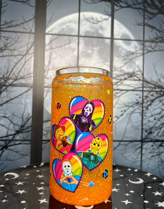 Glitter globe tumbler, filled with neon orange glitter, On the front is a decal with rainbow stripes inside each. Each heart has a different bad guy from a horror movie in it. Ghost Face, Freddy Kreuger, Jason Voorhees, and Michael Myers.