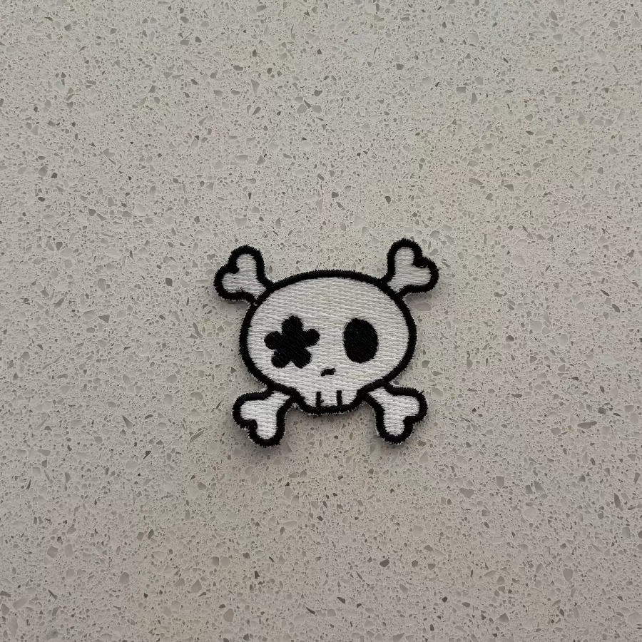 Skull and crossbones patch on a textured gray background