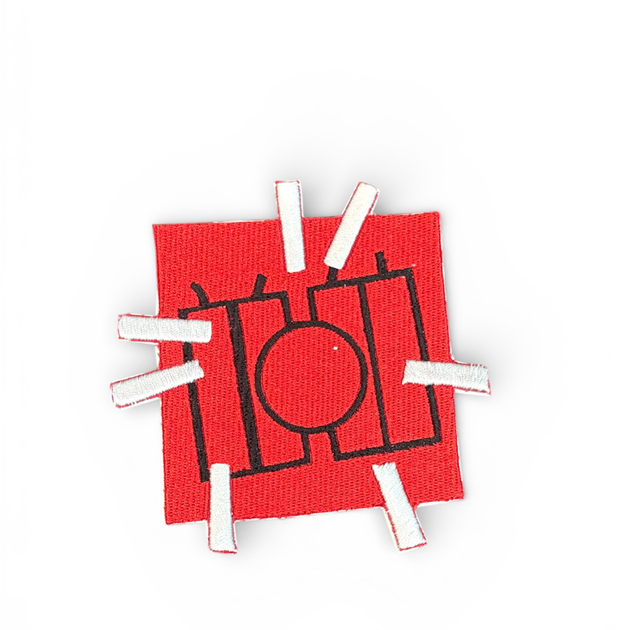 A red square patch, featuring 4 dynamite sticks outlined in black and a circle in the center on a white background