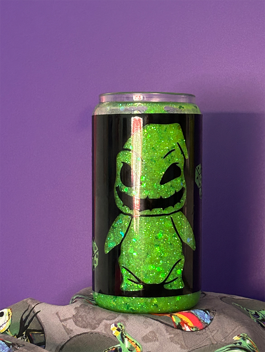 Glitter globe tumbler, filled with neon green glitter and black vinyl wrapped around it. On the wrap is a cut out of a small version of Oogie Boogie from The Nightmare Before Christmas